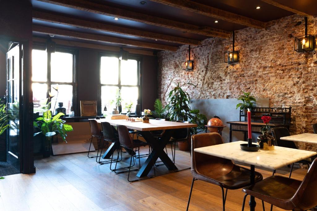 ein Restaurant mit Tischen und Stühlen und einer Backsteinmauer in der Unterkunft Hotel Hoksbergen in Amsterdam