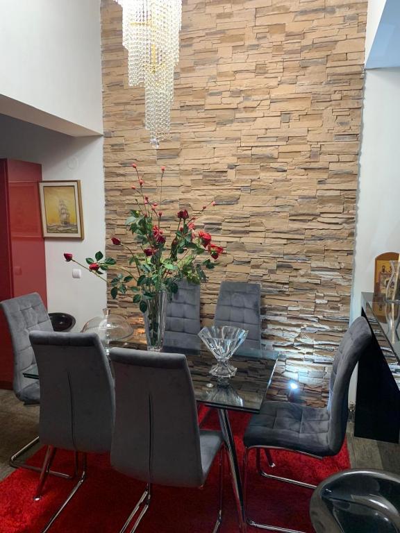 d'une salle à manger avec une table, des chaises et un mur en briques. dans l'établissement Two Floor Luxurious Villa #skg, à Thessalonique