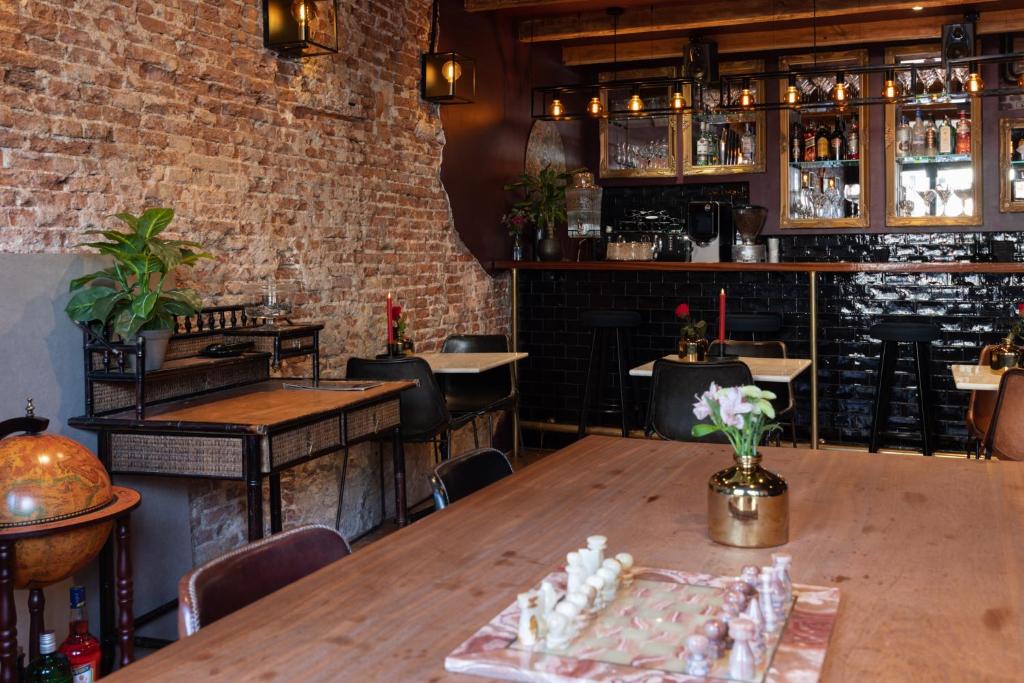 ein Restaurant mit einem Holztisch und einer Ziegelwand in der Unterkunft Hotel Hoksbergen in Amsterdam