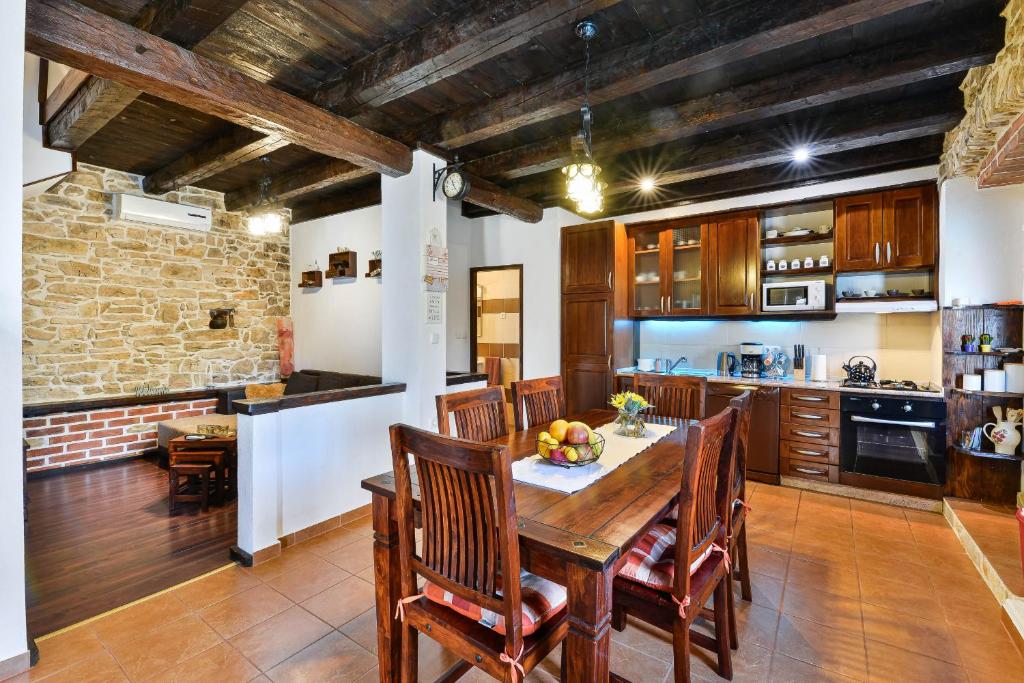 kuchnia z drewnianym stołem i krzesłami w obiekcie Stone Villa Mia with pool w mieście Debeljak