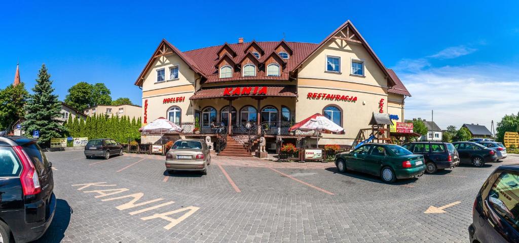 un gran edificio con coches estacionados en un estacionamiento en Kania Pokoje Gościnne, en Przodkowo