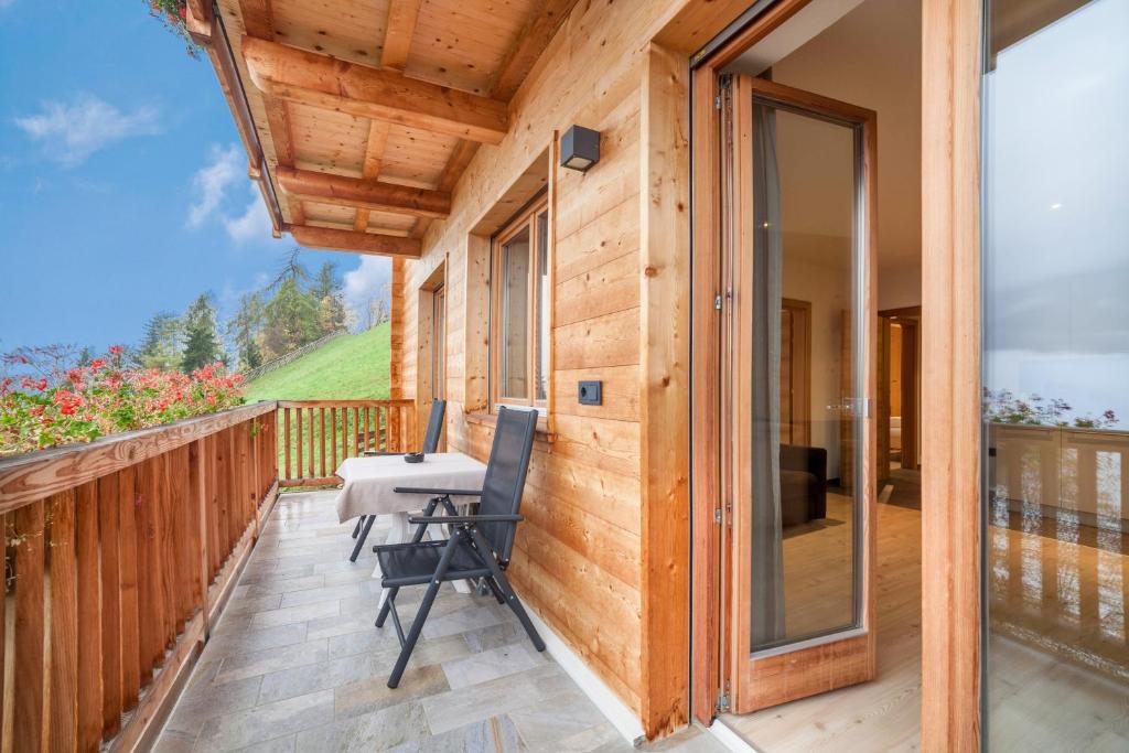 balcón con mesa y sillas en una pared de madera en Residence Kalchgruberhof Fichte, en Ultimo