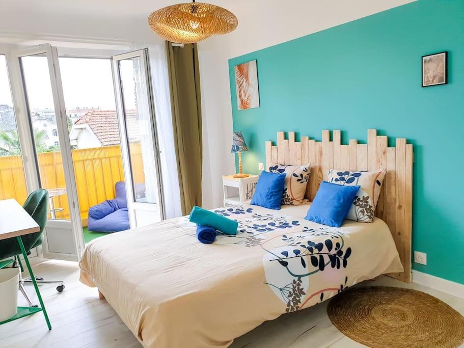 sypialnia z dużym łóżkiem z niebieskimi ścianami w obiekcie Cosy Summer 2CH - Parc Expo - 2 Balcons & stationnement gratuit w mieście Pau