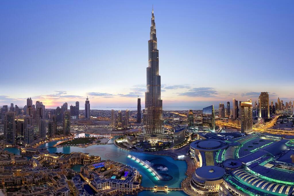 uma vista para uma cidade à noite com um edifício alto em Magnificent Luxury 3BR with Amazing Burj & Fountain view em Dubai
