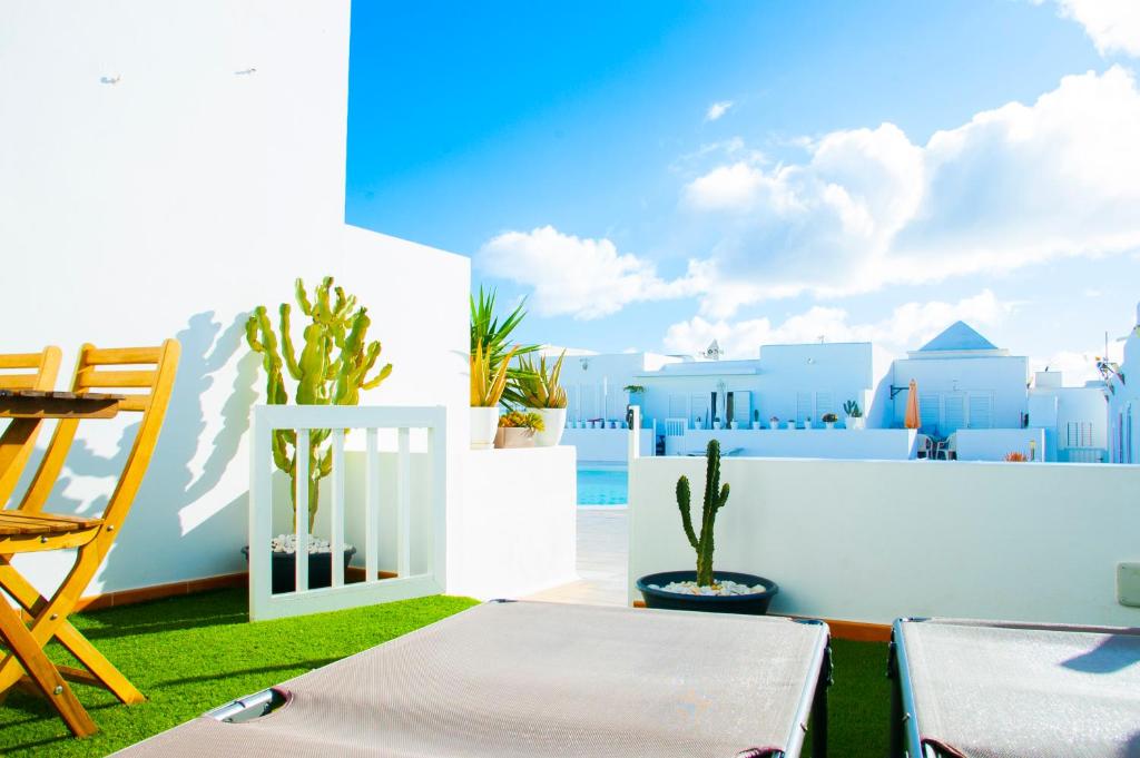 - un balcon avec une table, des chaises et des bâtiments dans l'établissement La Concha Beach apartament, à Arrecife