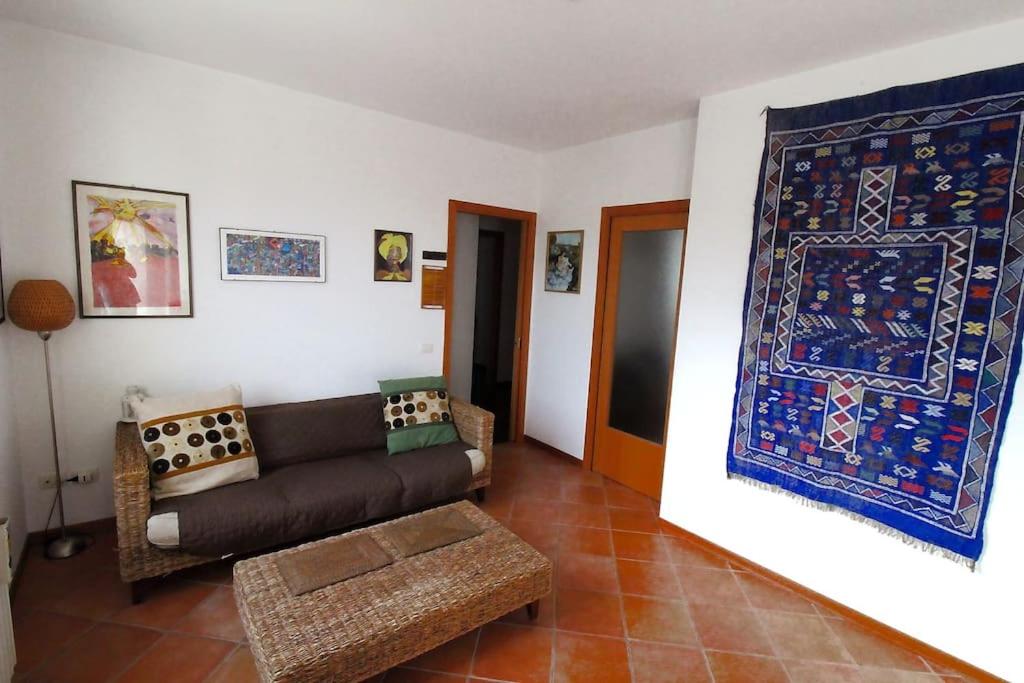 ein Wohnzimmer mit einem Sofa und einem Teppich an der Wand in der Unterkunft La casa di Sugar. Appartamento intero per 2 in Ancona