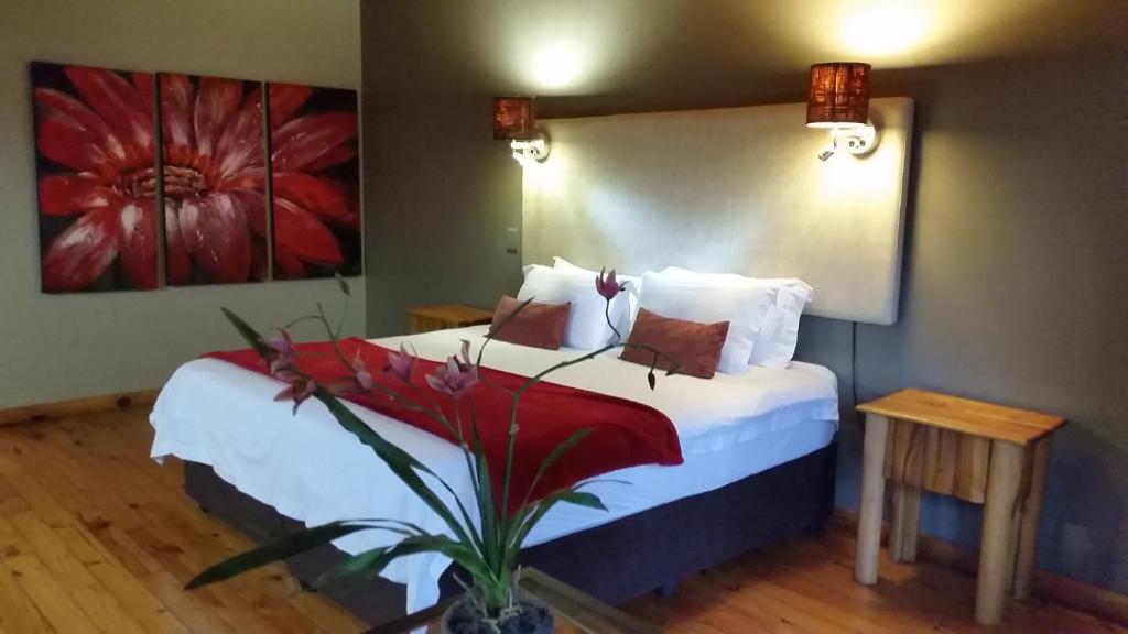 ThorndaleにあるThe Farmers Lodgeのベッドルーム1室(花の絵が飾られたベッド1台付)