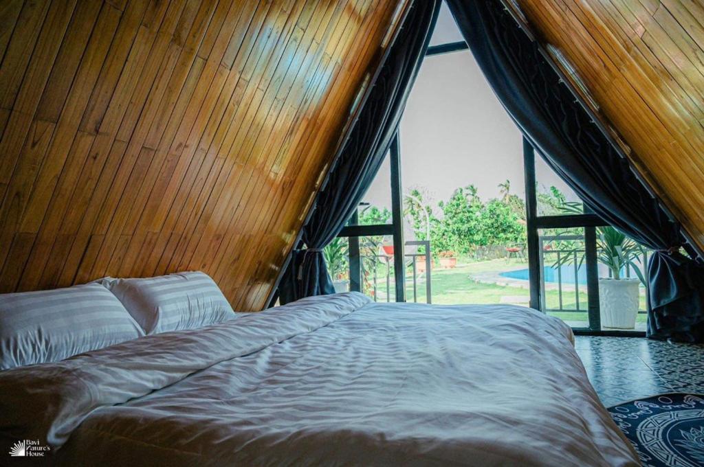 ハノイにあるNature’s House Ba Vi - Venue Travelの大きな窓のある部屋のベッド