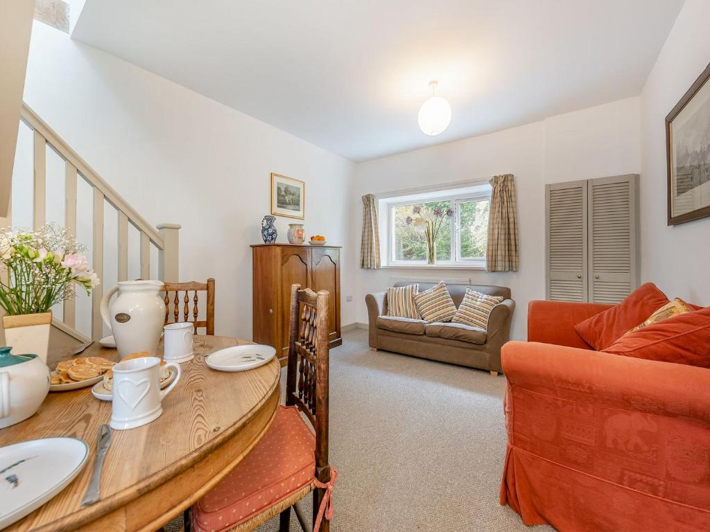 a living room with a table and a couch at 2 Cromwells Cottage-uk40929 in Pembroke