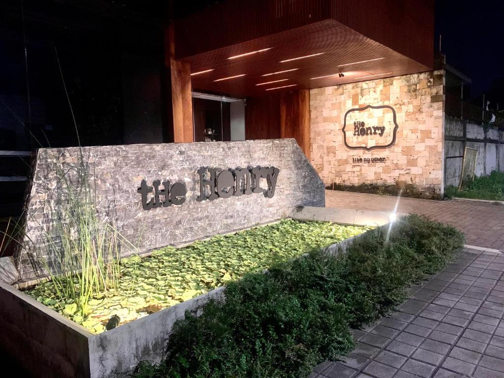 un banco de piedra sentado frente a un edificio en The Henry Hotel Roost Bacolod en Bacolod