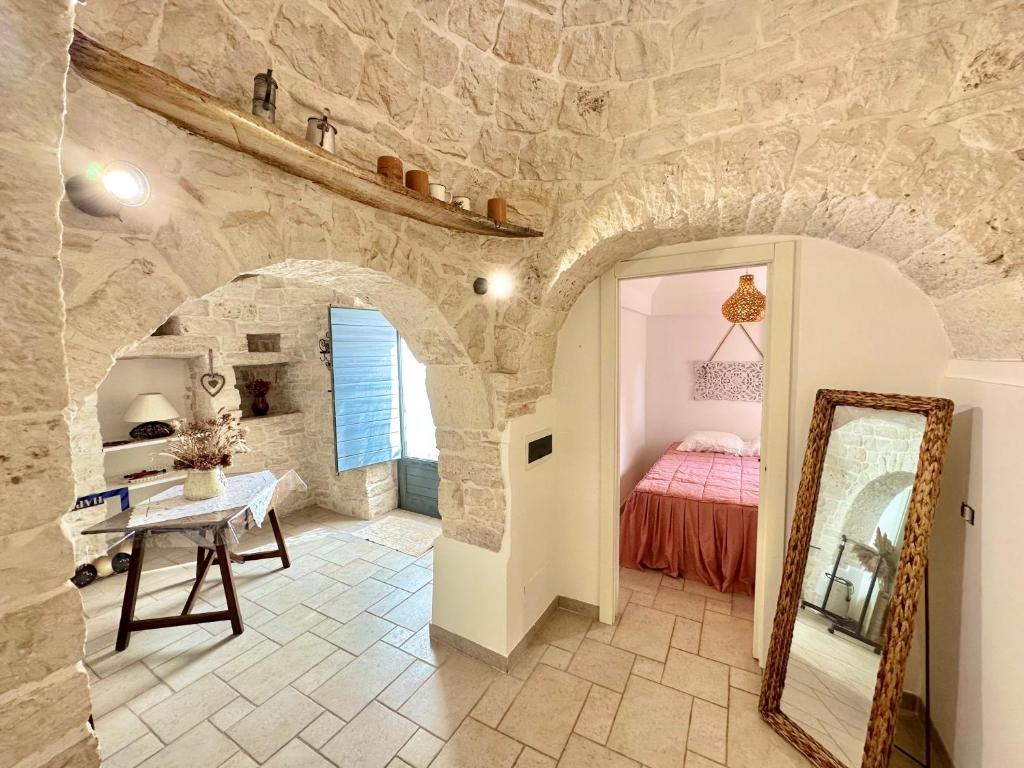 une chambre avec un lit et un miroir dans l'établissement Trullo il Carrubo, à Alberobello
