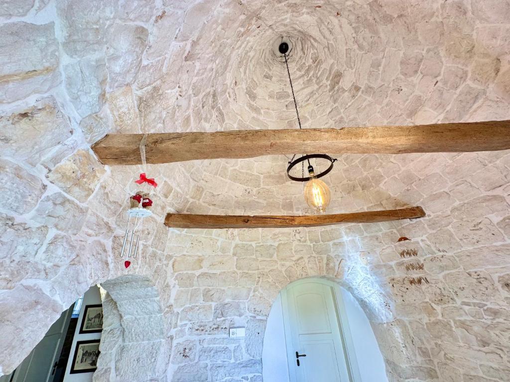 Cette chambre est dotée d'un mur en pierre et d'une horloge au plafond. dans l'établissement Trullo il Carrubo, à Alberobello 33 autres photos