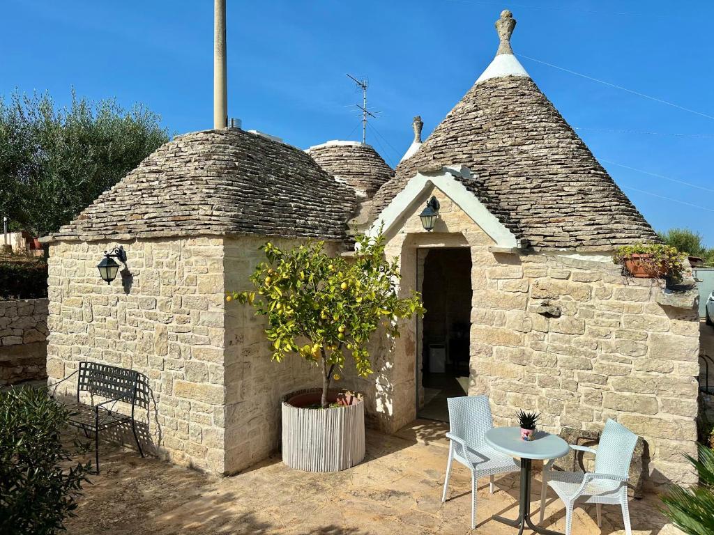 un petit bâtiment en briques avec une table et des chaises dans l'établissement Trullo il Carrubo, à Alberobello