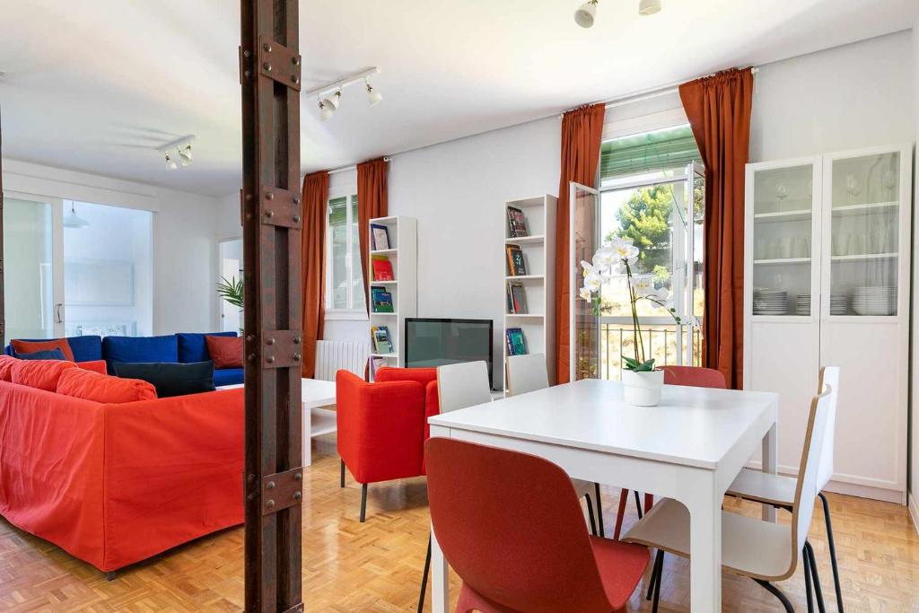 a living room with a white table and red chairs at Confortable piso 3 habitaciones en Retiro Atocha in Madrid