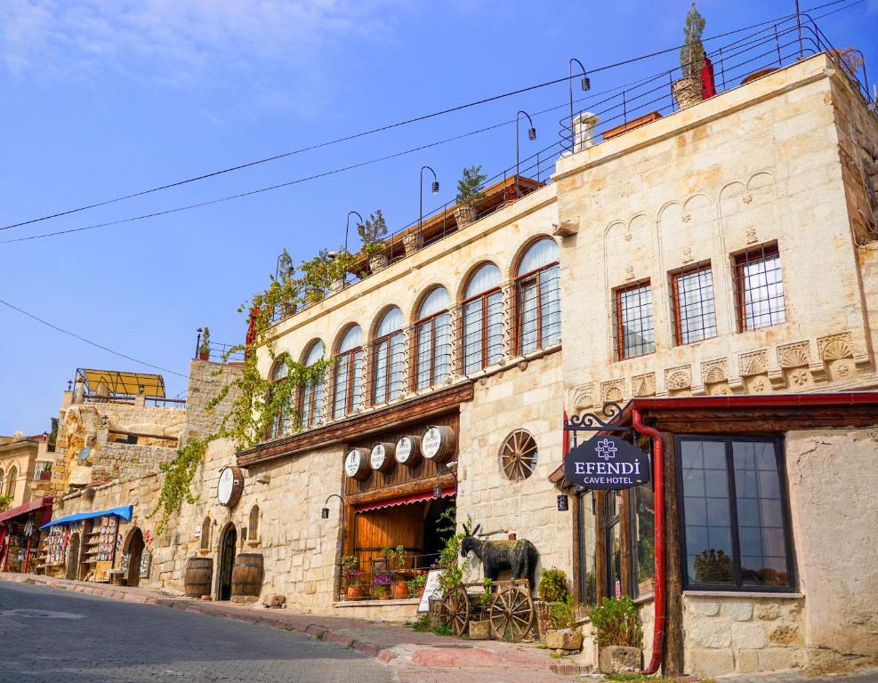 an old stone building on the side of a street at Efendi Cave Hotel in Urgup