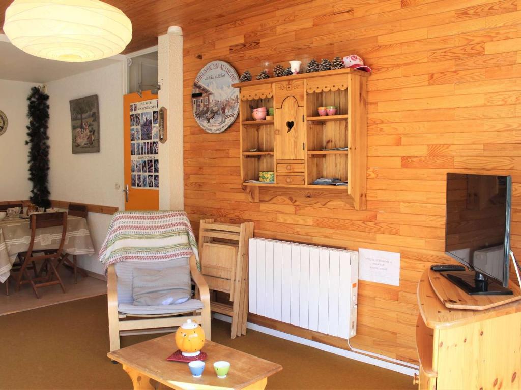 Cette chambre dispose d'un mur en bois, d'une table et d'une télévision. dans l'établissement Appartement 3 pièces à Vars Les Claux, pied des pistes, 6 couchages, proche commerces - FR-1-330B-33, à Vars