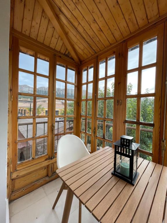 Habitación de madera con mesa de madera y silla blanca en Hospedium Casa Convento Sierra de María, en María