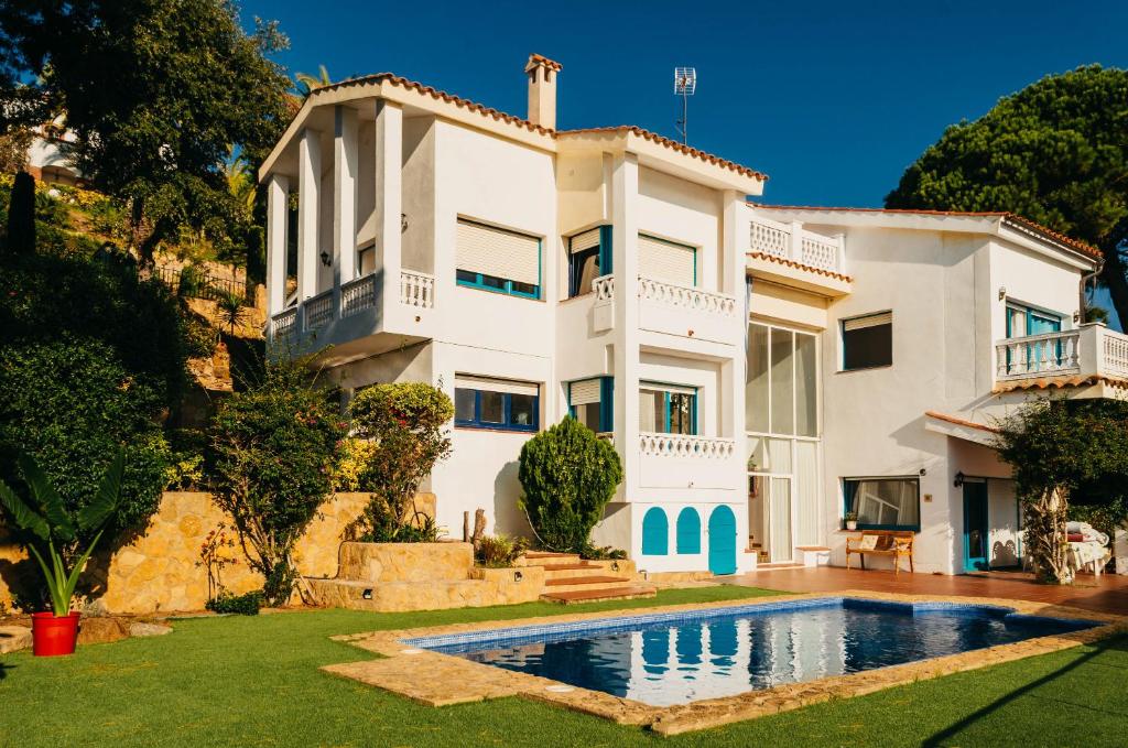 a large white house with a swimming pool in front of it at El Riu del Cel in Lloret de Mar