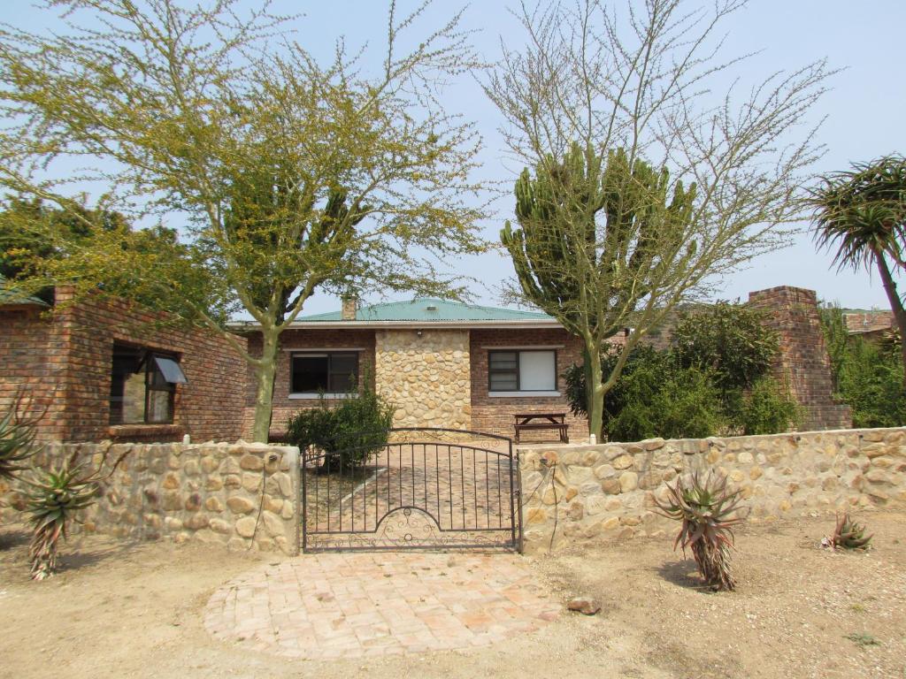 una casa de ladrillo con una puerta y una pared de piedra en Zungah Lodge, en Uitenhage