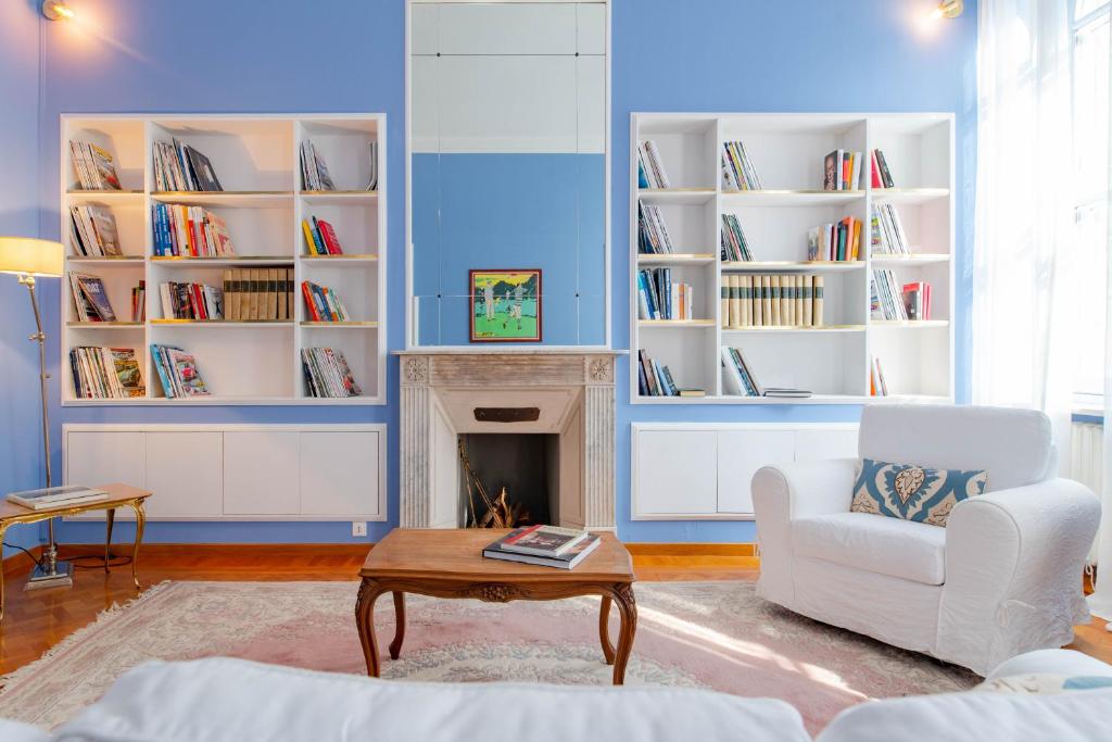un salon bleu avec une cheminée et une chaise blanche dans l'établissement The Queen, à Turin