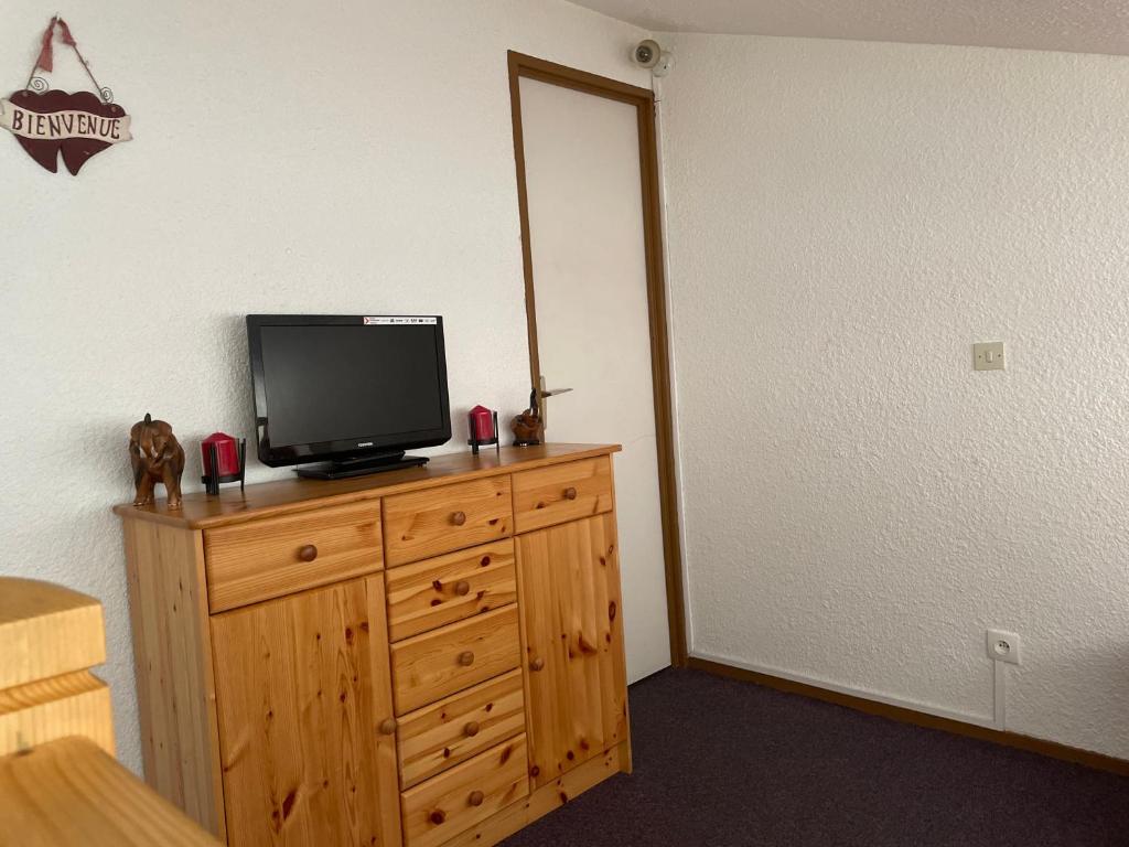 a room with a television on a wooden dresser at Appartement pour 6 personnes au pied des pistes au calme aux Menuires les Asters in Les Menuires