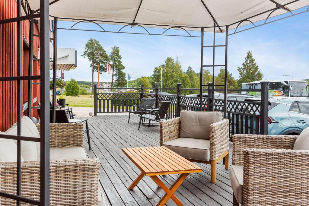 patio con sedie, tavoli e ombrellone di Best Western Hotell SoderH a Söderhamn