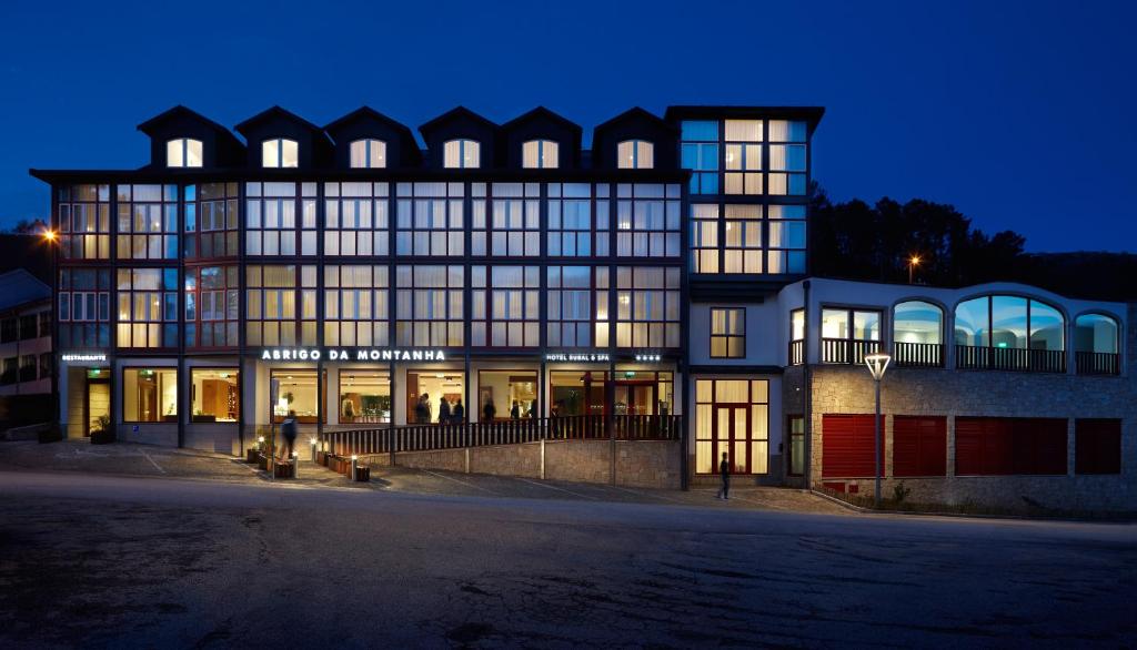 a large building with many windows at night at Abrigo da Montanha Hotel Rural in Sabugueiro