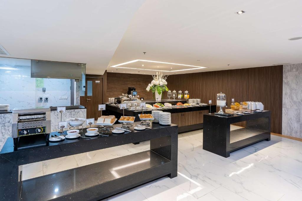 A self-service breakfast buffet arranged on two black stone counters.