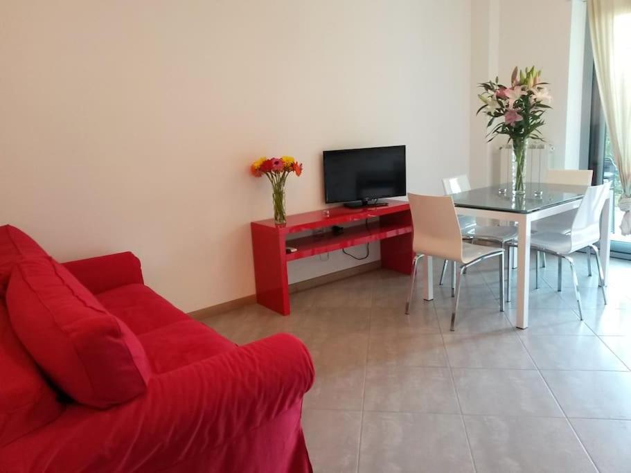 uma sala de estar com um sofá vermelho e uma mesa em Esclusivo appartamento alle Dune! Dalla piscina alla spiaggia in 30 mt! em Silvi Paese