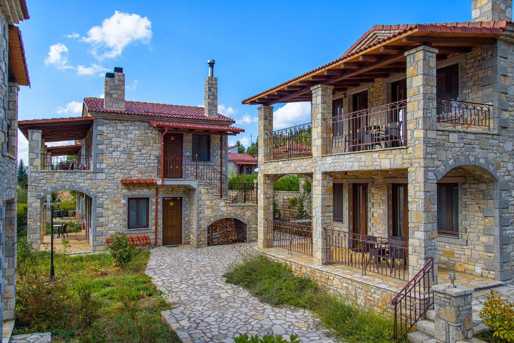 una imagen de una casa de piedra con patio en Omalia Village, en Ano Chora