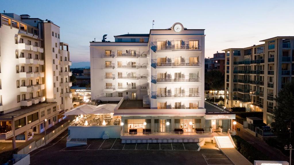 um grande edifício branco com um relógio em cima em Hotel Continental em Rimini