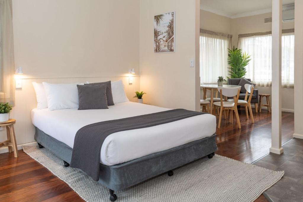 um quarto com uma cama grande e uma sala de jantar em Pacific Motel 06 em Forster