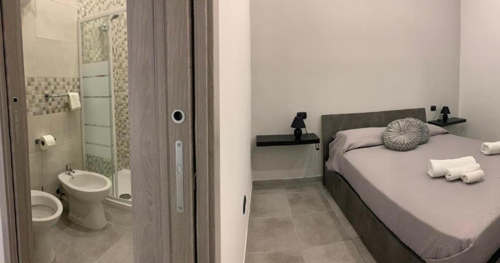 een slaapkamer met een bed en een badkamer met een toilet bij miris apartment fast comfortable naples airport capodichino 25 minutes walk self check-in in Napels