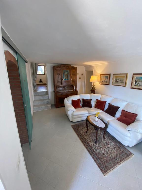 a living room with a white couch and a table at Casa Elena e Lori in Fosdinovo