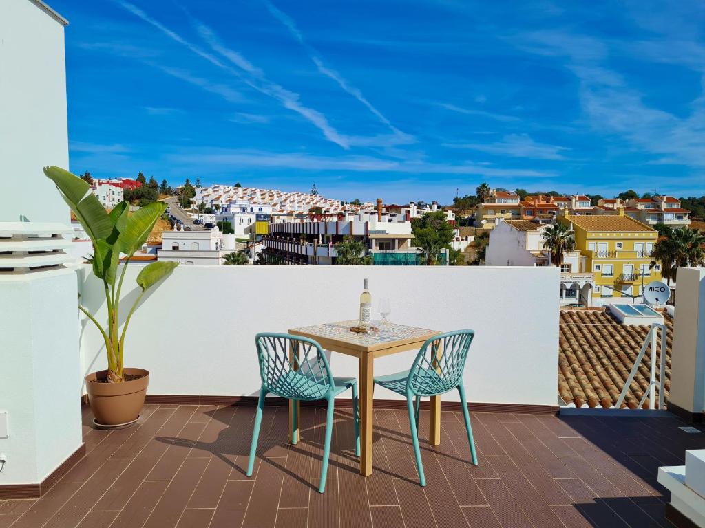 een tafel en stoelen op een balkon met uitzicht bij CASINHA DE FERRAGUDO - Terraço Privado, AC, WiFi, Centro 250m in Ferragudo