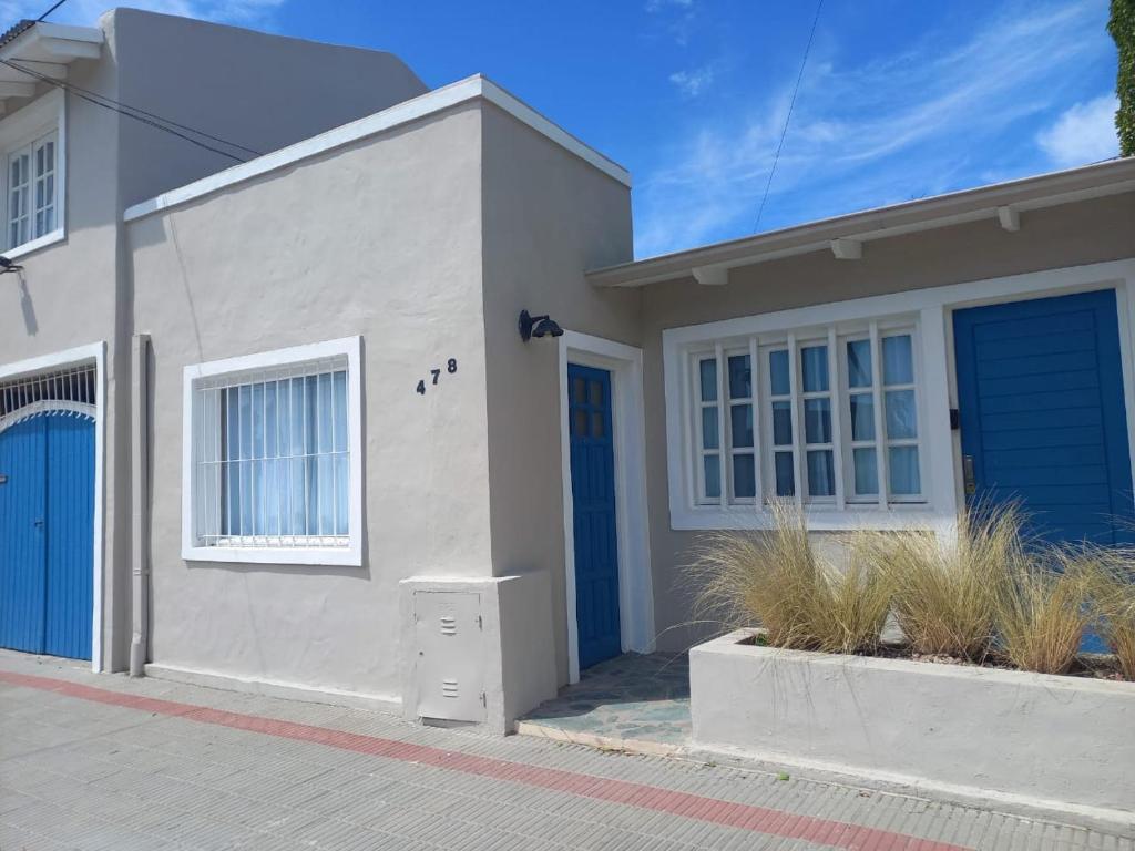 una casa con una puerta azul en una calle en La Puerta Azul, en Tandil