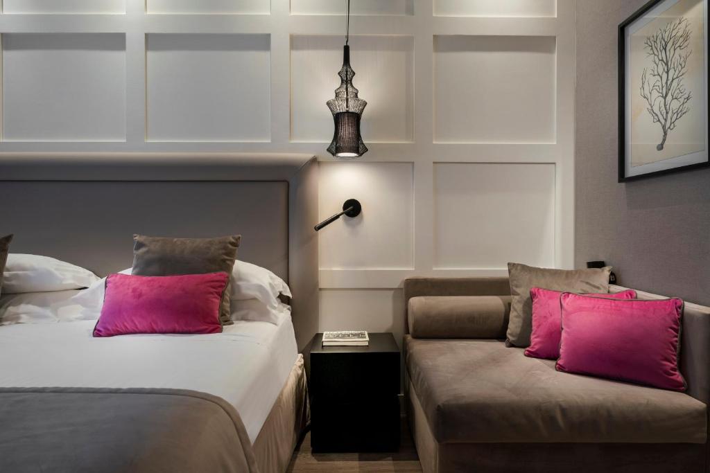 リッチョーネにあるホテル ルンゴマーレのピンクの枕が付くベッド2台が備わるホテルルームです。