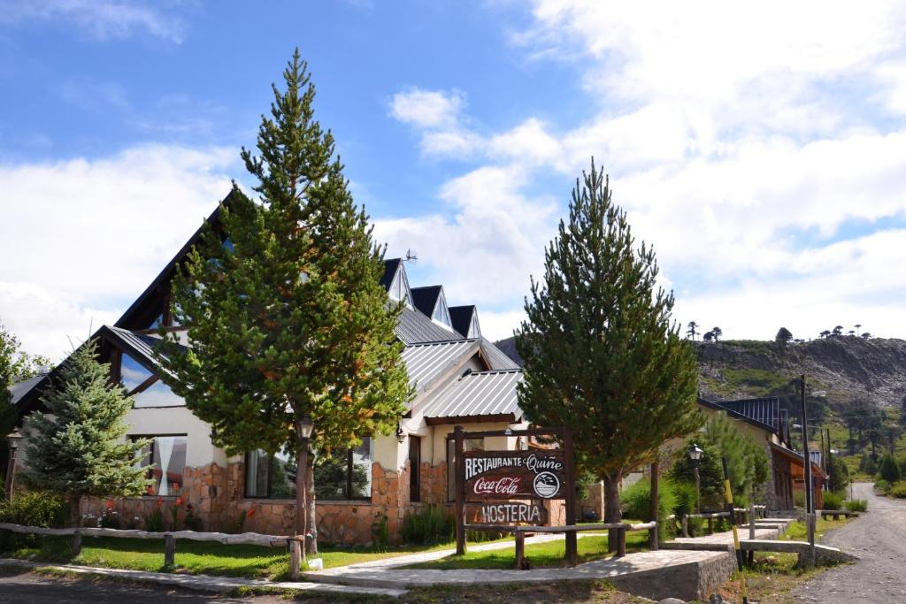 a large house with trees in front of it at Hosteria Quiñe in Caviahue