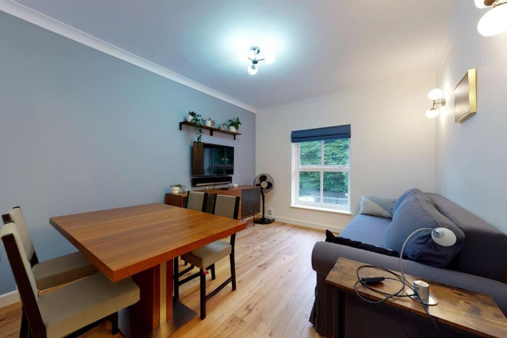 een woonkamer met een bank en een tafel bij Lovely 2-bedroom flat with parking near Highgate in Londen