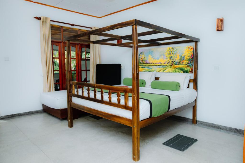 um quarto com uma cama de dossel e uma televisão em Celestial Inn em Mirissa