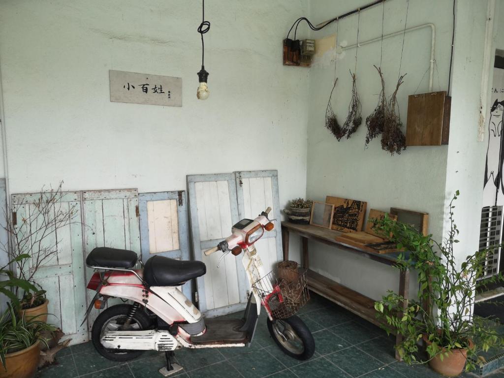un scooter estacionado en una habitación con plantas en REQUELstore, en Sungai Pelik