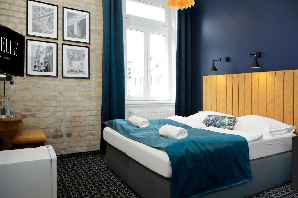 a bedroom with a bed with blue walls and a window at Giselle Vintage Doubles - Adults Only in Budapest