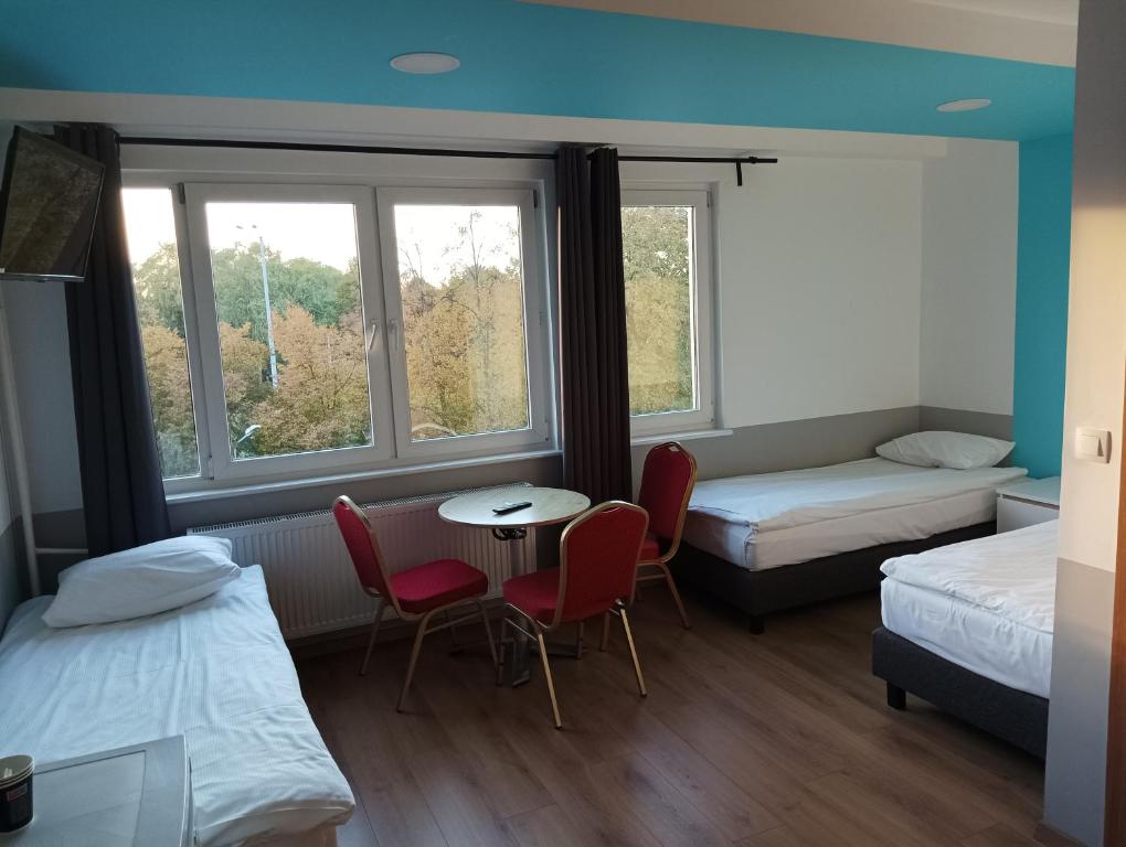 Pokój z 2 łóżkami, stołem i krzesłami w obiekcie Ośrodek Pomeranka w Gdańsku