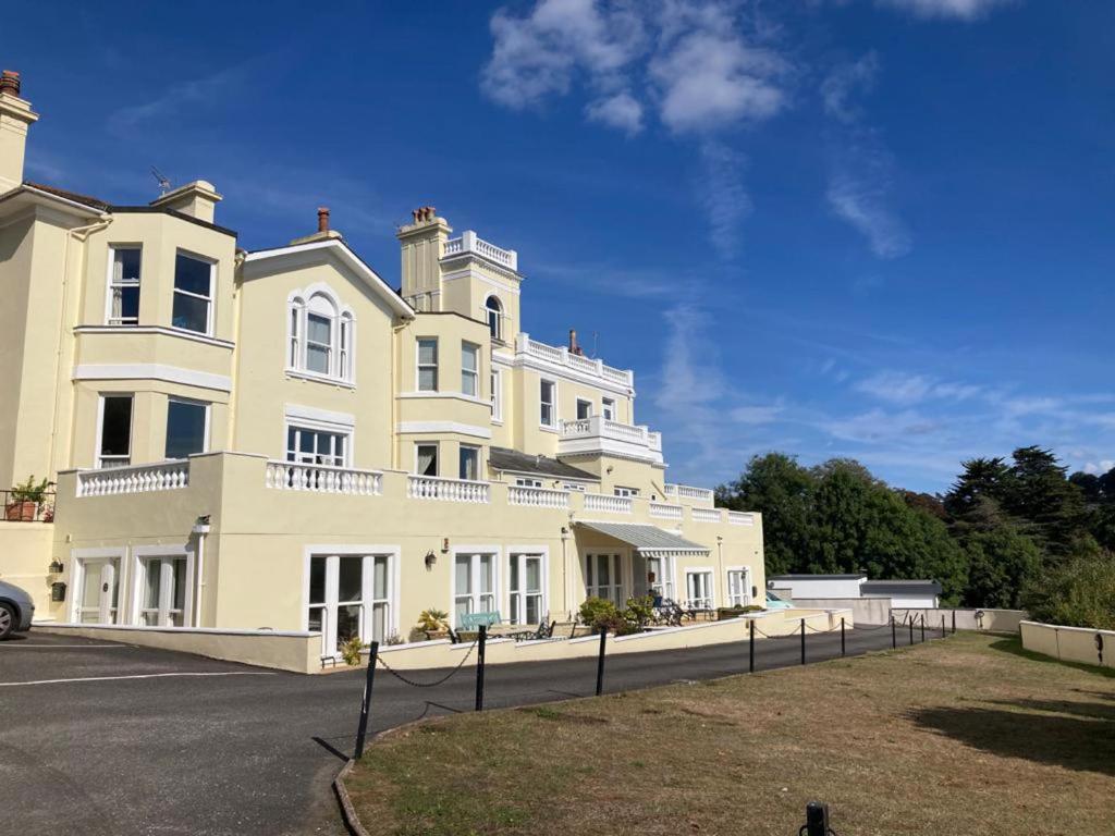 a large white building with a yard in front of it at Upmarket 2 bedroom apartment with sea views in Torquay