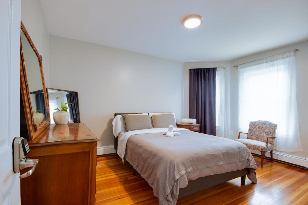 a bedroom with a bed and a dresser with a mirror at Boston Queen Bedroom in Boston