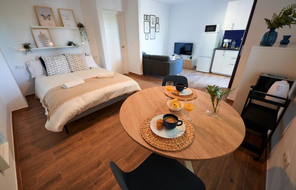 sala de estar con mesa y cama en Apartamentos Sierra de Las Nieves, en Ronda