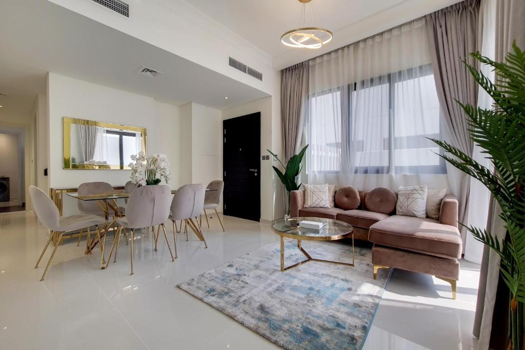 ein Wohnzimmer mit einem Sofa und einem Tisch in der Unterkunft Primestay - Damac Hills 2 Aster Villa 3 Bedroom in Dubai