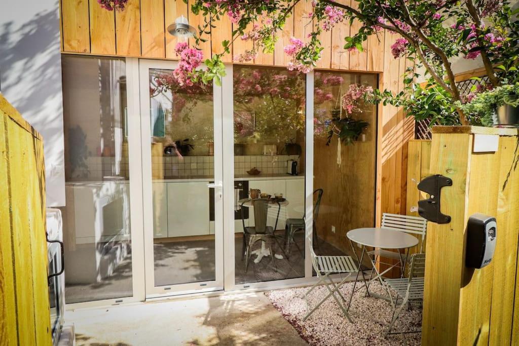 Habitación con puertas de cristal y mesa con perro en Suite Vivien Durand - Cœur de ville historique, en Burdeos