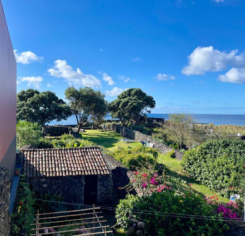 a view of a garden with the ocean in the background at Casa O Refúgio in Lagoa