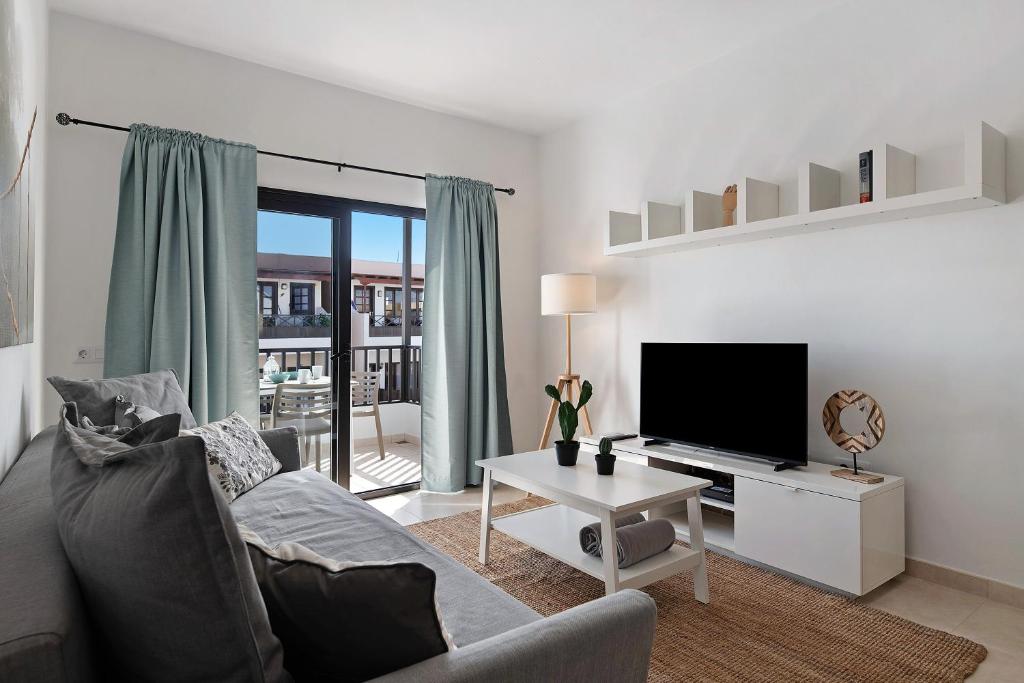 a living room with a couch and a flat screen tv at Apartamento La Estrella I in Playa Honda